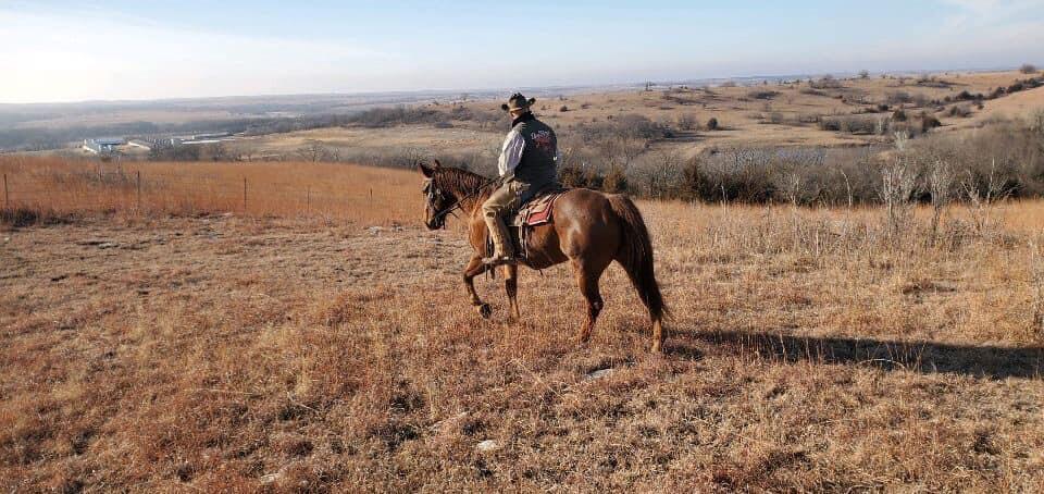 Joe Ammann riding on horseback and overlooking 2UW Brush Creek Ranch in the Flint Hills of Westmoreland, Kansas